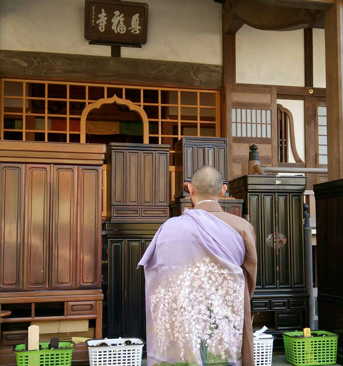 本堂の前で処分を待つ仏壇・仏具・位牌等に読経をする八王子・興福寺の雨宮住職